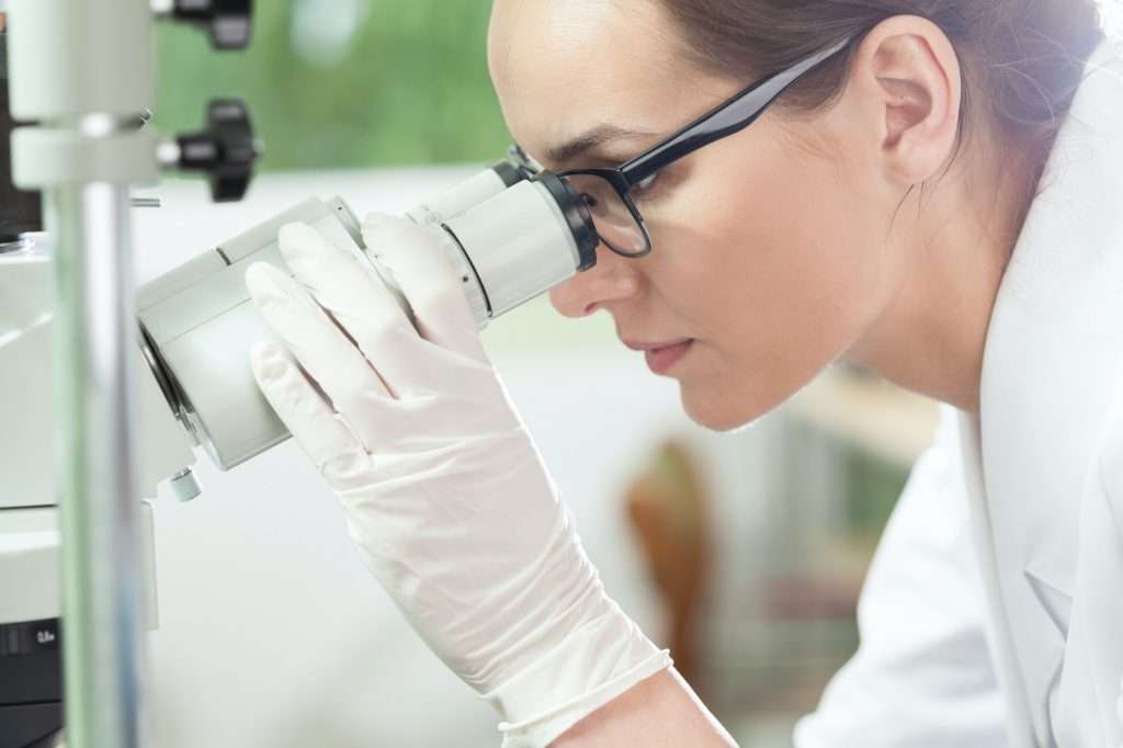 Woman using microscope in laboratory